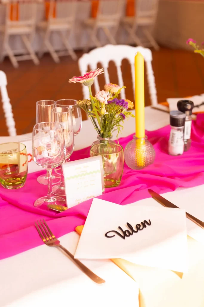 Table de mariage coloré en rose et orange, avec soliflore de fleurs et bougeoir